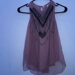It’s a cute blouse with a dusty pick color. also has a bead design in the front.